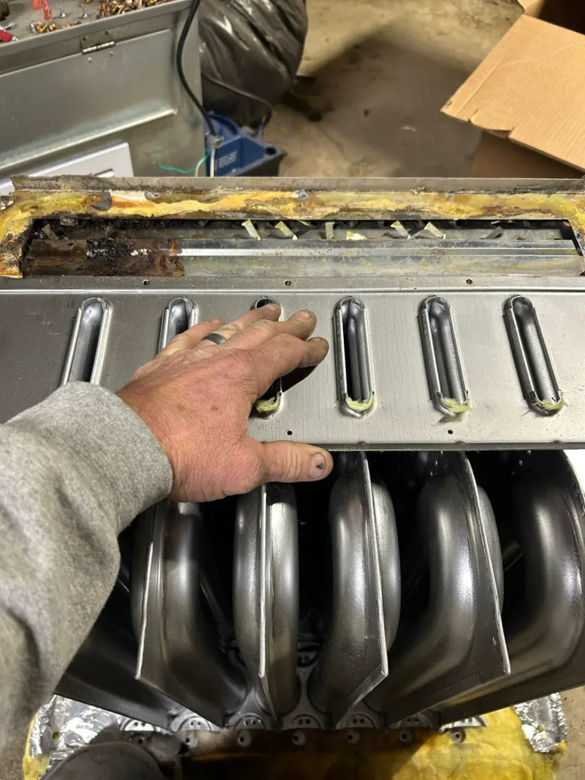 Technician checking furnace burners during a heating repair in New Paris, OH